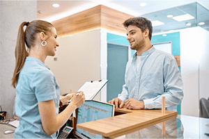 A patient speaking with a front desk member