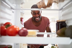 man looking in his refrigerator