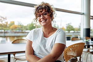 a smiling woman sitting in a cafe