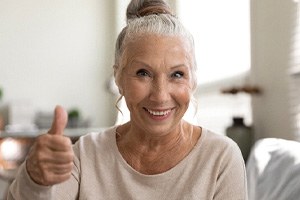 Older woman smiling after dental implant placement