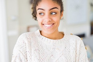 Woman in a white sweater smiling at home