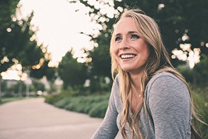 Woman sitting on side of the road smiling