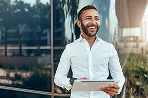 Bearded man holding a tablet and smiling